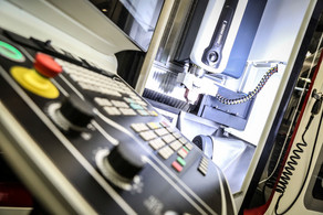 Maschinenbau_01 Eine große graue Maschine mit einer Tastatur zur Bedienung und großen roten Tasten.